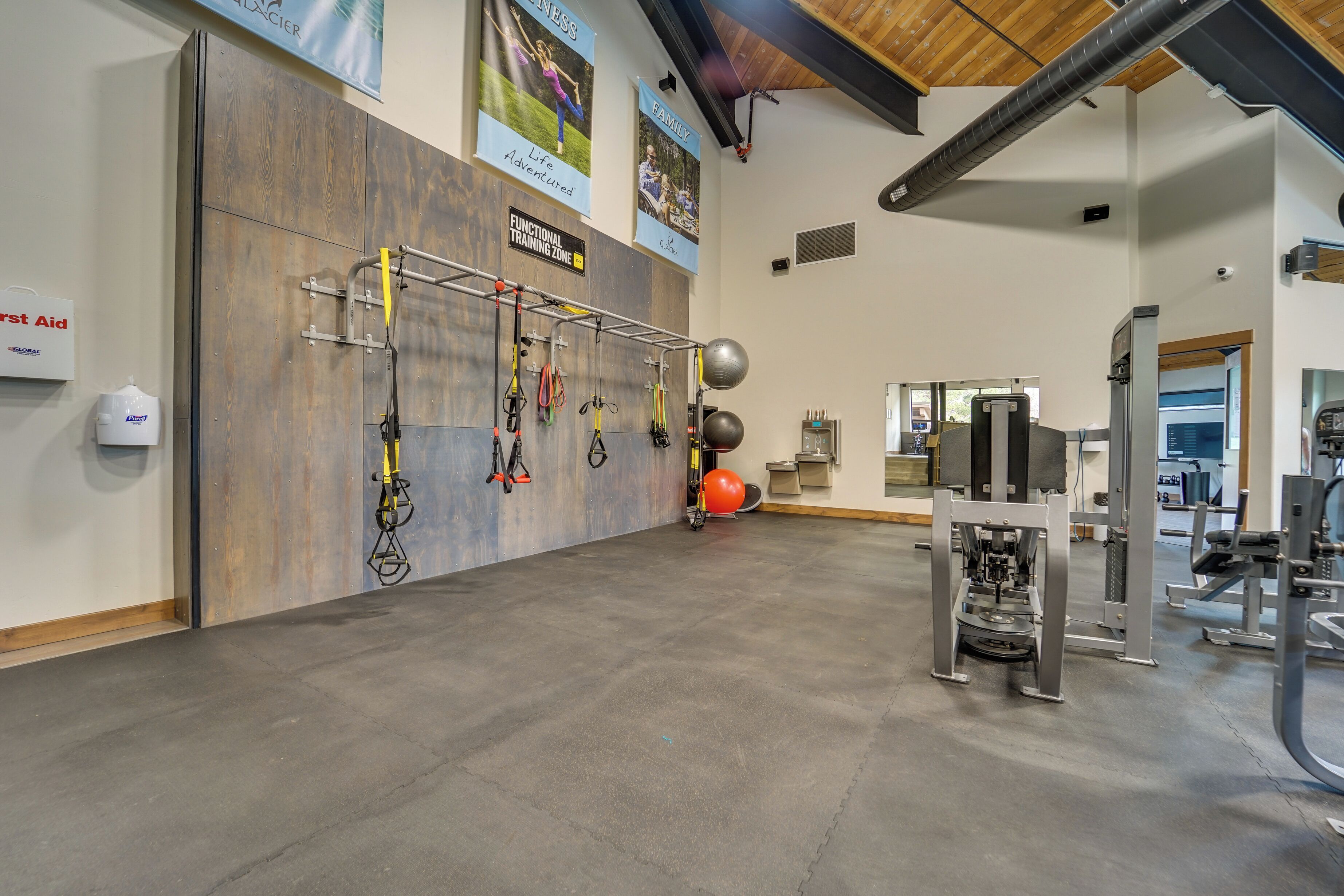 A spacious gym with various exercise equipment, including a pull-up bar and weight machines.