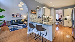 A modern kitchen with a central island, pendant lighting, and a dining area with a chandelier. - Tranquil Greensboro Home w/ Fire Pit! (Greensboro)