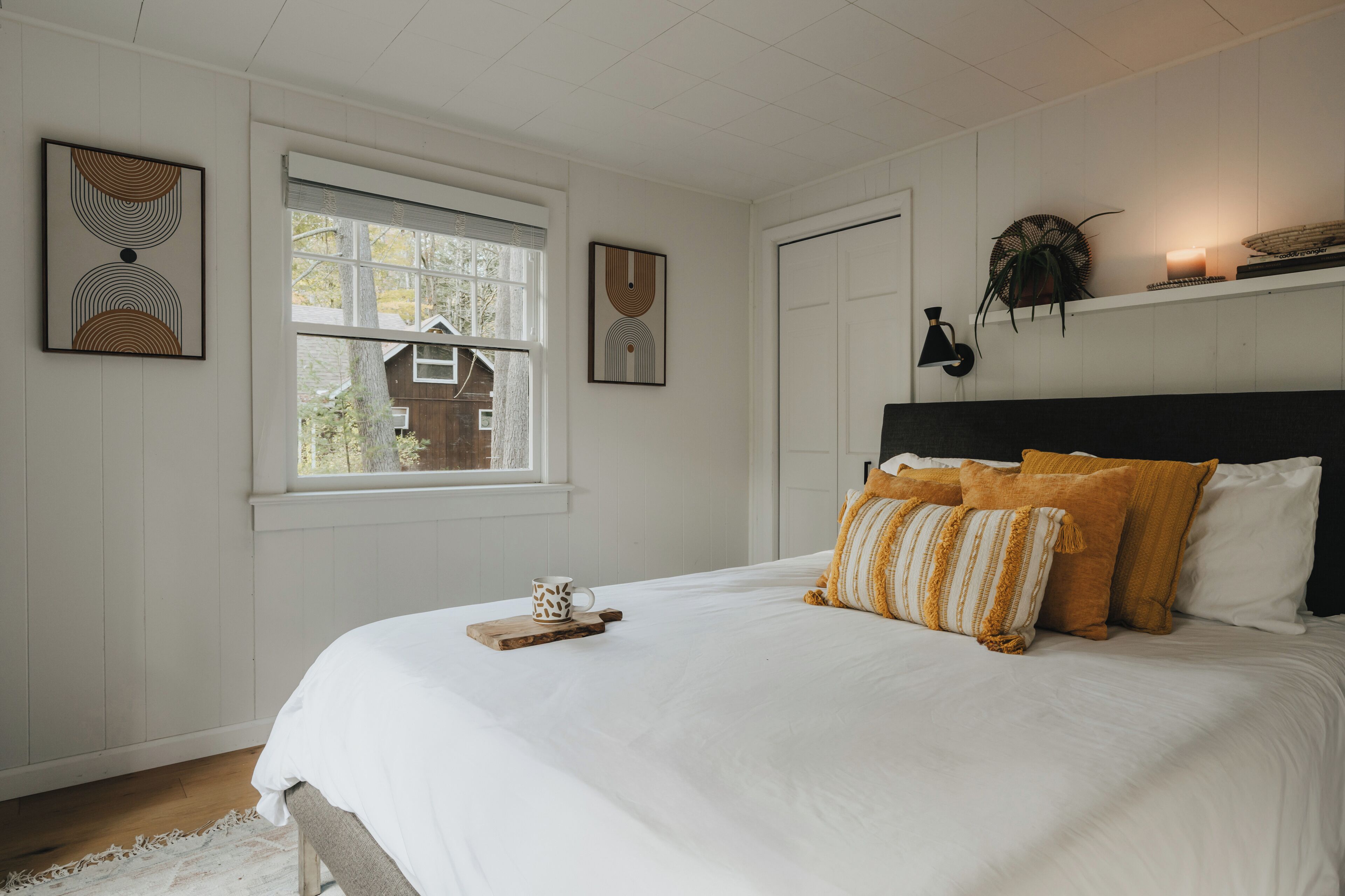 Quarto com uma cama grande, janela e decoração na parede.