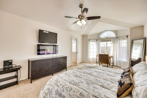 A bedroom with a bed, dresser, TV, ceiling fan, and a desk with chair. - Colorado Vacation Rental w/ Private Hot Tub (Monument)