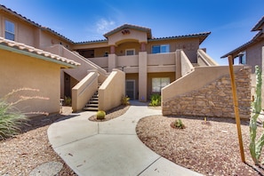 A multi-story building with a central staircase, a stone wall, and a landscaped area with small plants. - Work or Play! Resort-style Scottsdale Retreat (Scottsdale)