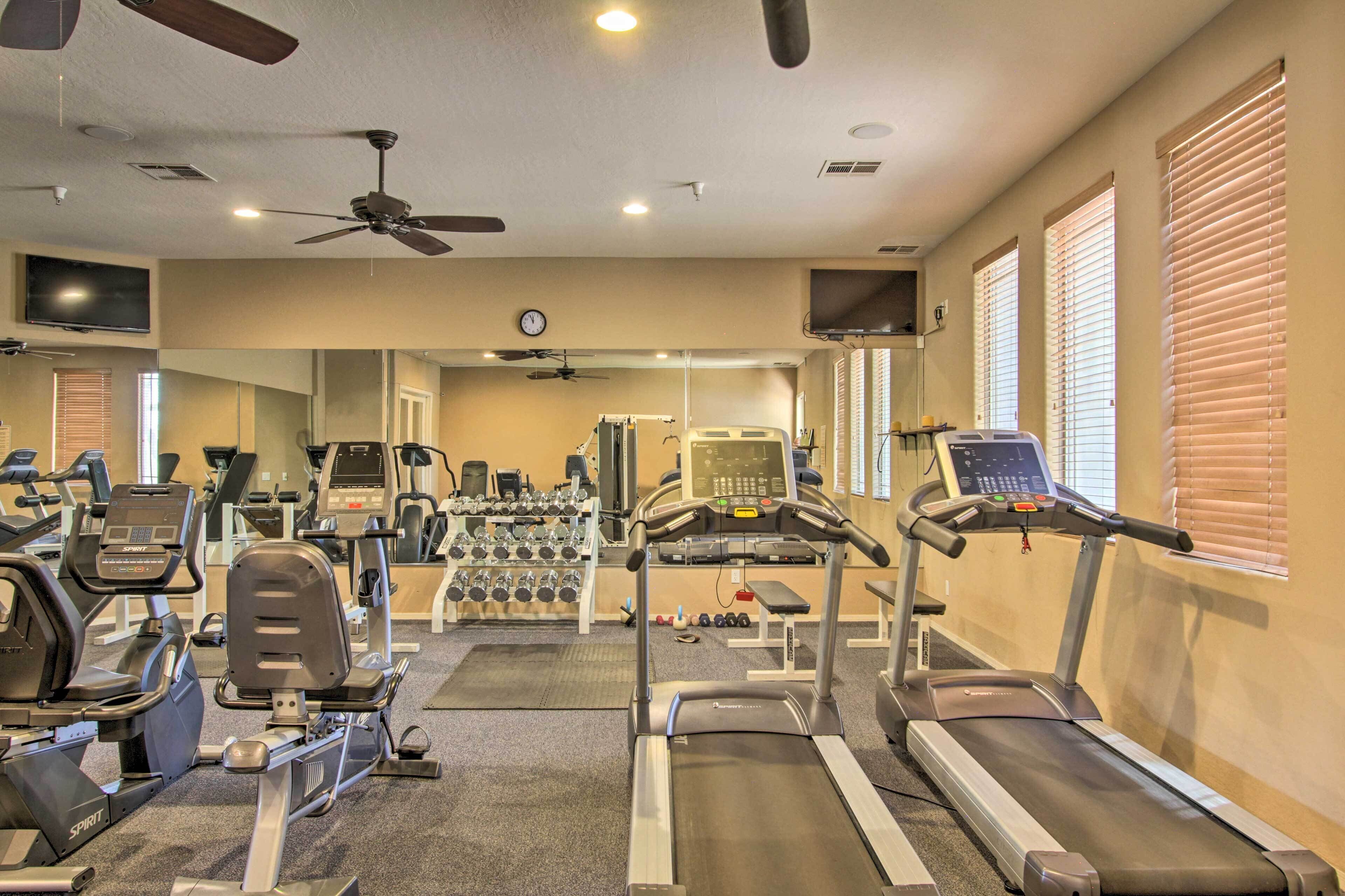 Une salle de sport équipée de tapis de course, de vélos d’exercice et de poids libres.