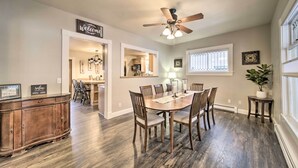 A dining area with a wooden table and chairs, a ceiling fan, and a 'Welcome' sign. - Charming Kellogg Home Near Outdoor Activities (Kellogg)