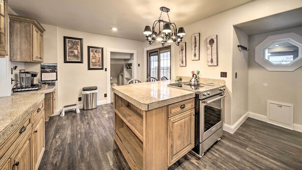 A kitchen with wooden cabinets, a granite countertop, a built-in oven, and a chandelier. - Charming Kellogg Home Near Outdoor Activities (Kellogg)