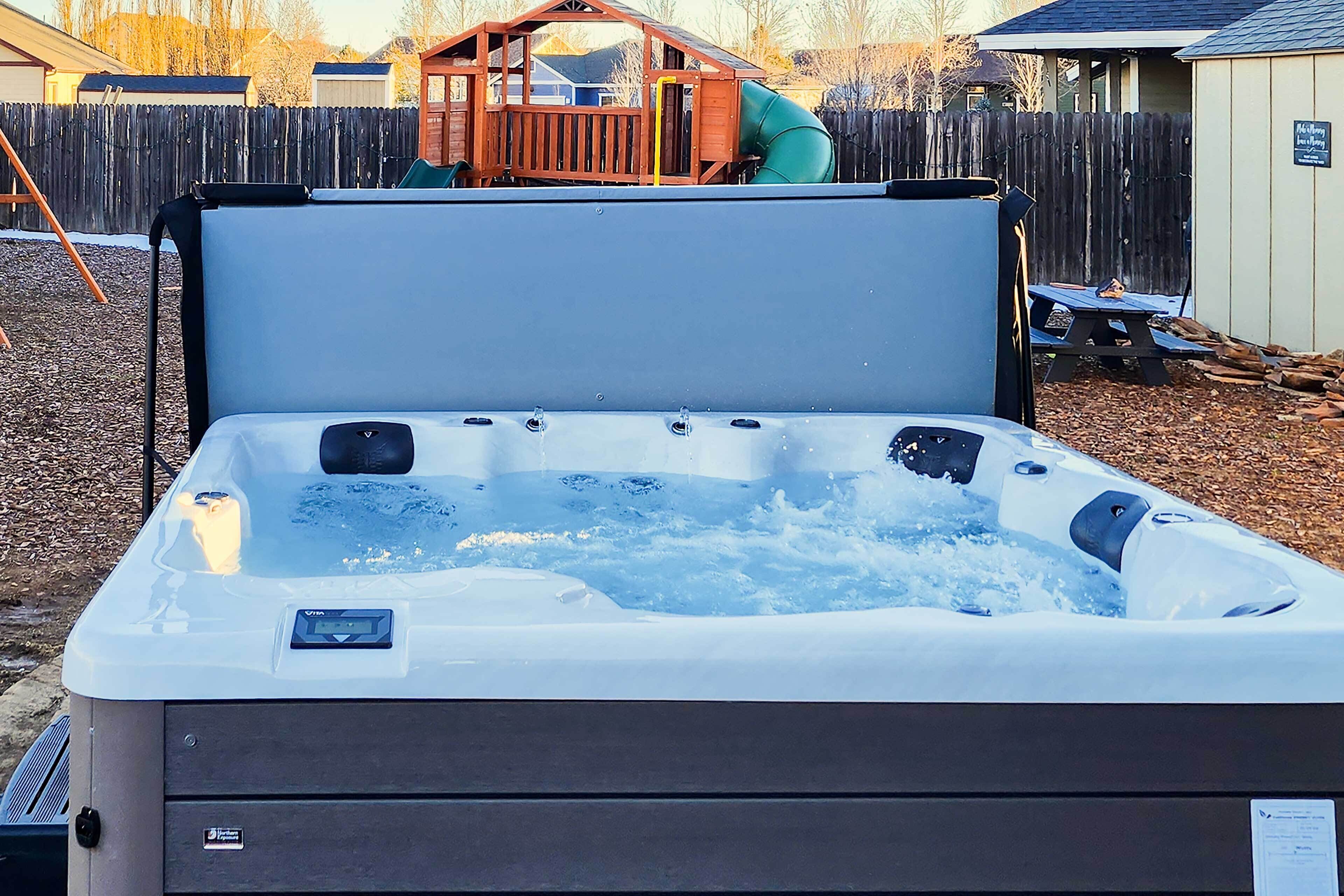 A hot tub with a control panel and a wooden deck in the background.