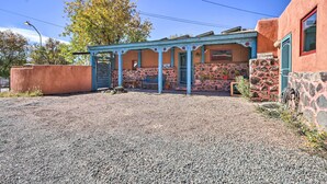 A building with a covered patio area, stone walls, and a blue door. - Artsy Santa Cruz Apartment w/ Shared Fire Pit! (Santa Cruz)