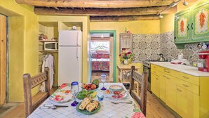 A kitchen with yellow cabinets, a wooden ceiling, and a dining table set with food and drinks. - Artsy Santa Cruz Apartment w/ Shared Fire Pit! (Santa Cruz)
