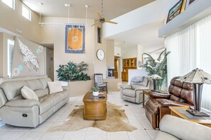 A spacious living room with a sofa, armchair, and a coffee table.