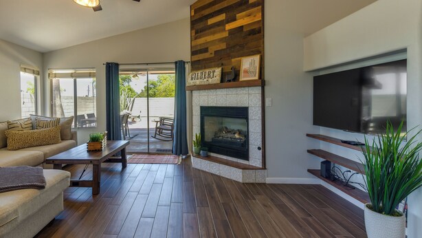 A living room with a fireplace, a sofa, a coffee table, and a television. - Gilbert Home w/ Pool < 5 Mi to Downtown! (Gilbert)