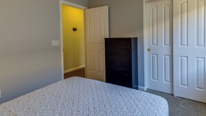 A bedroom with a bed, a dresser, and a door leading to another room. - Gilbert Home w/ Pool < 5 Mi to Downtown! (Gilbert)