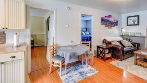 A cozy living room with a dining area, a sofa, and a coffee table. There is a painting on the wall and a ceiling light. - 2 Mi to Dtwn: Cozy Getaway in Fairbanks! (Fairbanks)