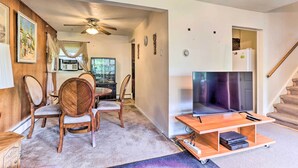 A living room with a TV, wooden chairs, a ceiling fan, and a staircase. - Family-friendly Allentown Abode w/ Backyard! (Allentown)