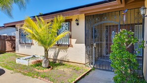 A house with a gated entrance, a small garden with a palm tree, and a metal gate with decorative patterns. - El Cajon Oasis w/ Backyard 17 Mi to Dtwn San Diego (El Cajon)