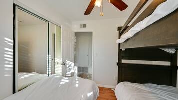 A bedroom with a bunk bed, a ceiling fan, and a large mirror.