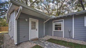 Une maison d’habitation avec un porche à l’avant, une porte et une fenêtre.