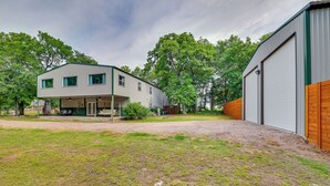 Ein modernes, zweistöckiges Gebäude mit überdachter Terrasse und einer großen Garage.