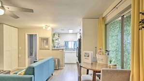 A modern kitchen with a dining area, a blue sofa, and a wooden table with chairs. - 2 Mi to Asu: Studio w/ Private Hot Tub in Tempe (Tempe)