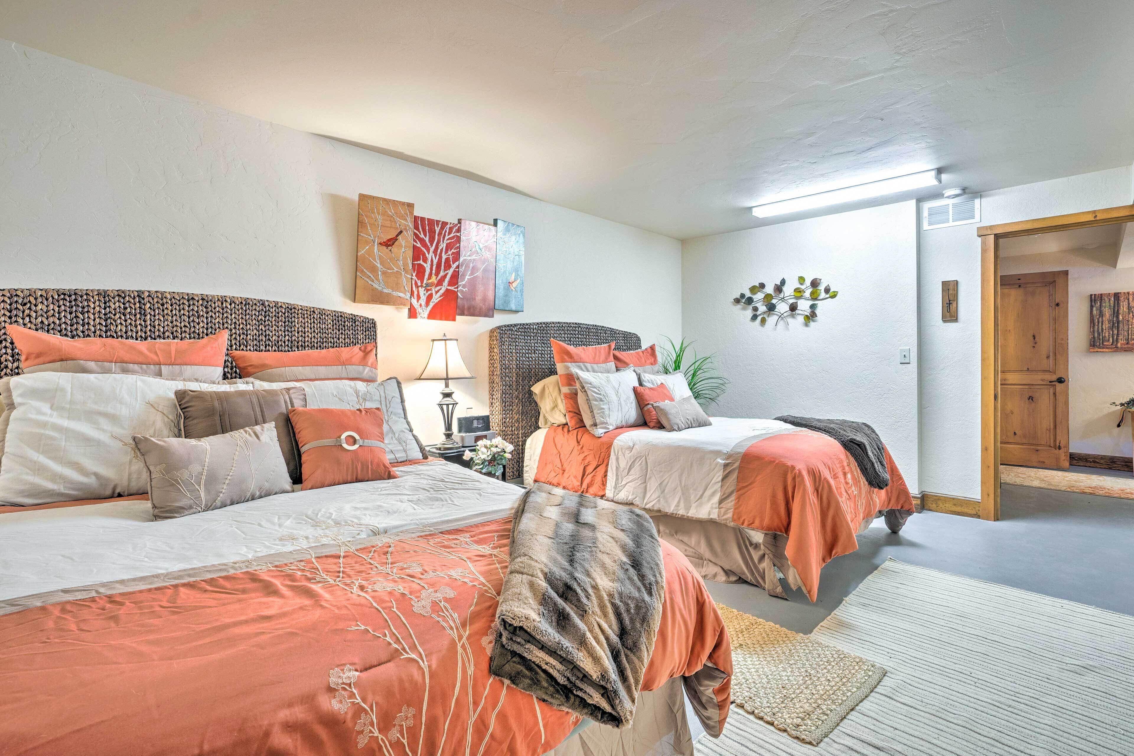A bedroom with two beds, each with a distinct headboard, and a nightstand between them.