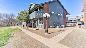 A building with a balcony, outdoor seating, and a clear sky.
