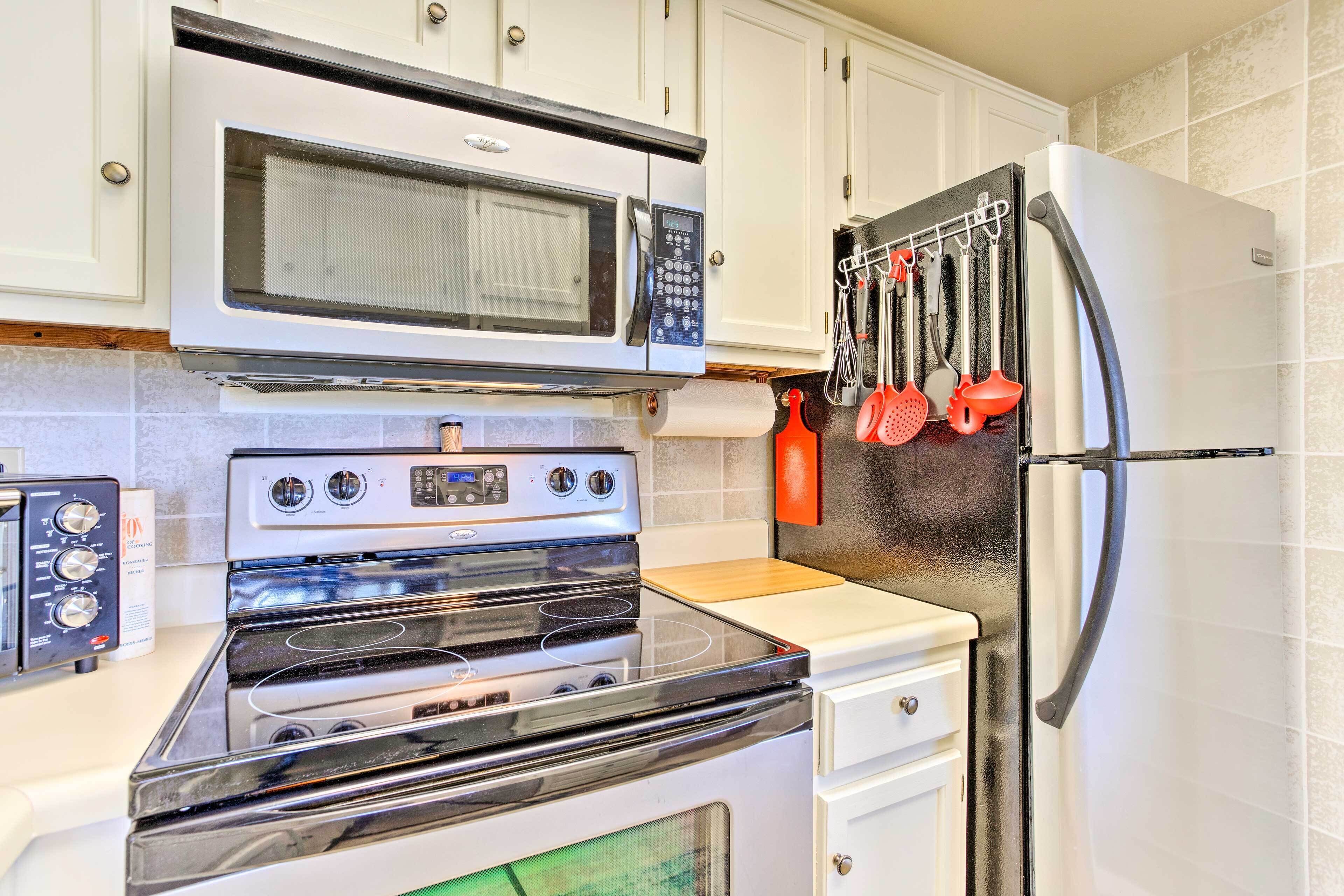 A kitchen with a microwave, oven, and refrigerator.