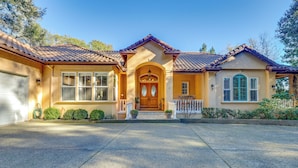 A two-story house with a front porch, a garage, and a well-maintained lawn. - Santa Rosa Home w/ Private Pool & Tennis Court (Santa Rosa)