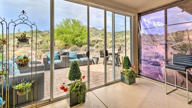 A spacious patio with outdoor seating, large windows, and potted plants. - Gold Canyon Getaway w/ Golf + Community Perks (Gold Canyon)