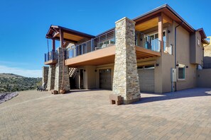 A modern two-story house with a stone facade, large windows, and a spacious outdoor area. - Prescott Vacation Rental w/ Game Room & Mtn Views! (Prescott)