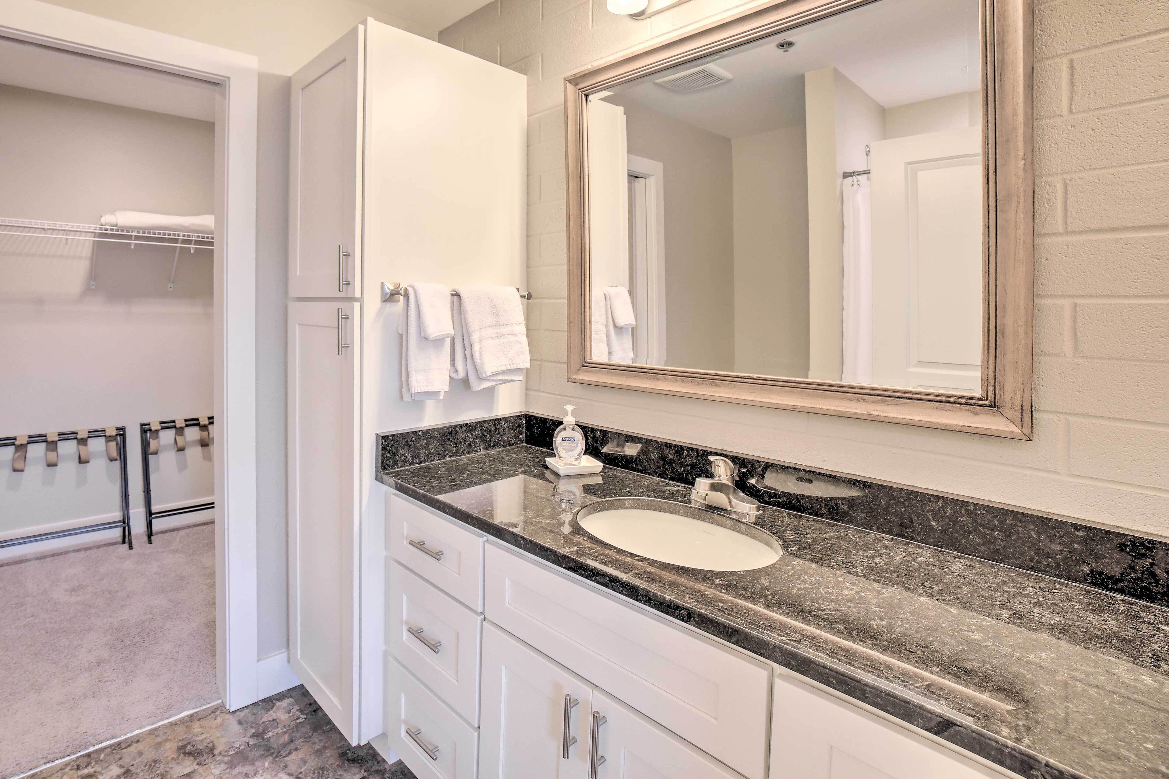 A bathroom with a white sink, a large mirror, and a towel rack.