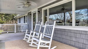 A covered porch with two rocking chairs and a ceiling fan. - Mattituck Home w/ Fireplaces - Near Wineries (Mattituck)