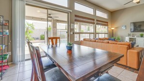 A spacious dining area with a large wooden table, a built-in bench, and a sliding glass door leading to an outdoor patio. - Private Pool & Patio: Family Retreat in Mesa (Mesa)