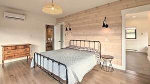 Un dormitorio con cama, cómoda y una mesita.
