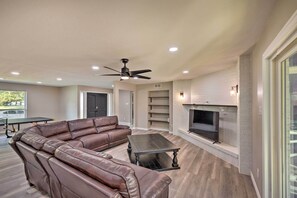 A spacious living room with a leather sectional sofa, a coffee table, a fireplace, and a ceiling fan. - Spacious Fort Worth Getaway < 4 Mi to Dtwn! (Fort Worth)