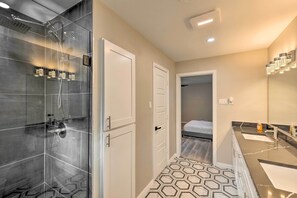 A modern bathroom with a glass-enclosed shower, a vanity with a mirror, and a hexagonal patterned floor. - Spacious Fort Worth Getaway < 4 Mi to Dtwn! (Fort Worth)