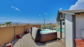 Un jardin avec un jacuzzi, une piscine et une vue sur les montagnes.