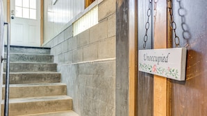 A staircase with a sign reading "Unoccupied" and a metal railing. - Walk to Lake Michigan & Dtwn: Coastal Grand' (Ludington)