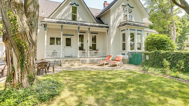 A two-story house with a porch, a covered patio, and a well-maintained lawn. - Walk to Lake Michigan & Dtwn: Coastal Grand' (Ludington)