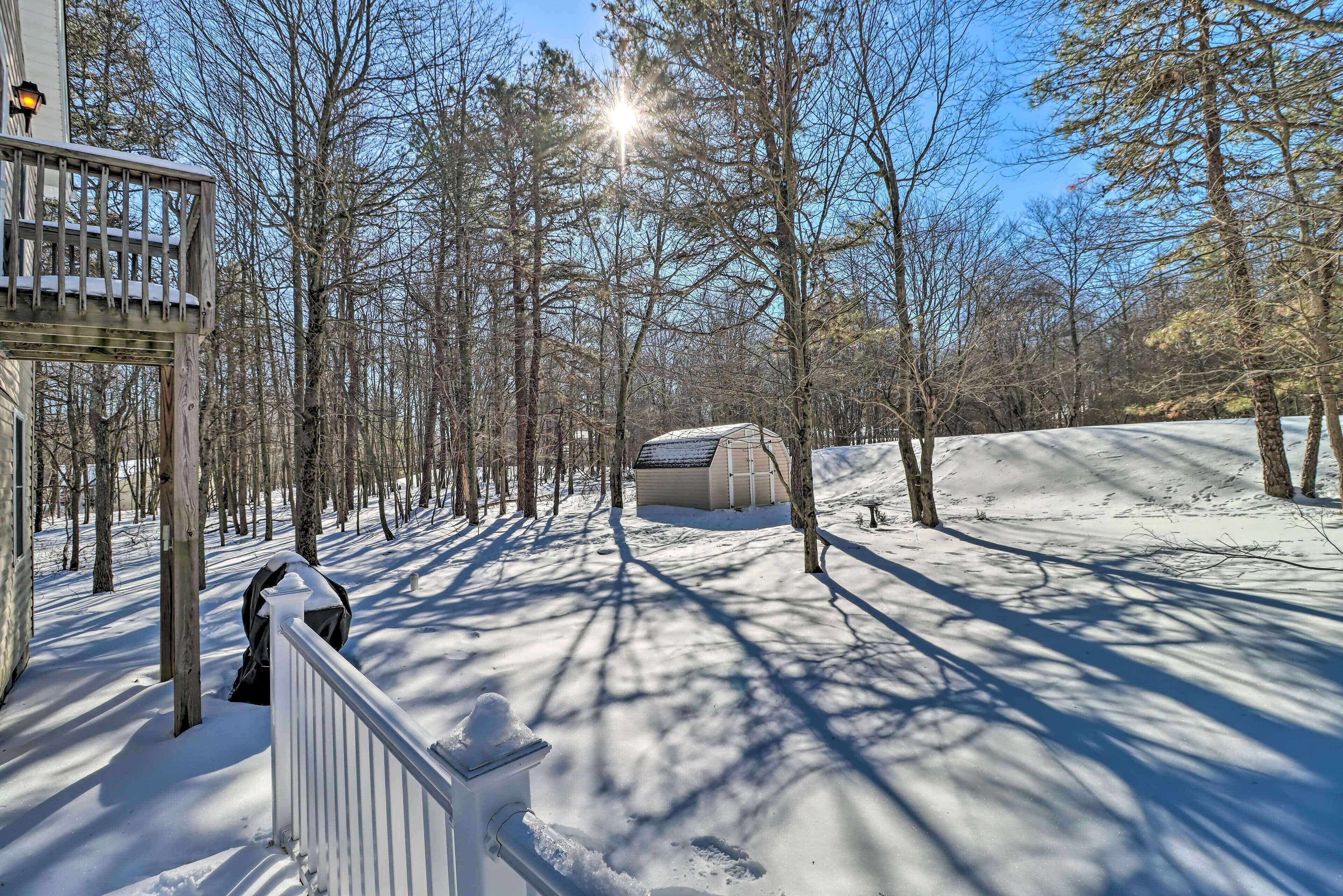 A snow-covered landscape with a cabin and a wooden deck.