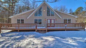 A two-story house with a gabled roof, large windows, and a front porch with a wooden railing. - Deck, Pool, Trails Access: Pocono Family Home! (Albrightsville)