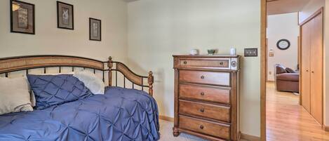 A bedroom with a bed, a dresser, and a ceiling fan.