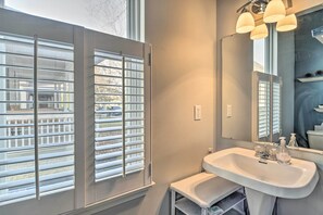 A bathroom with a large window, a sink, and a mirror. - Cozy Indianapolis Home w/ Private Hot Tub! (Indianapolis)
