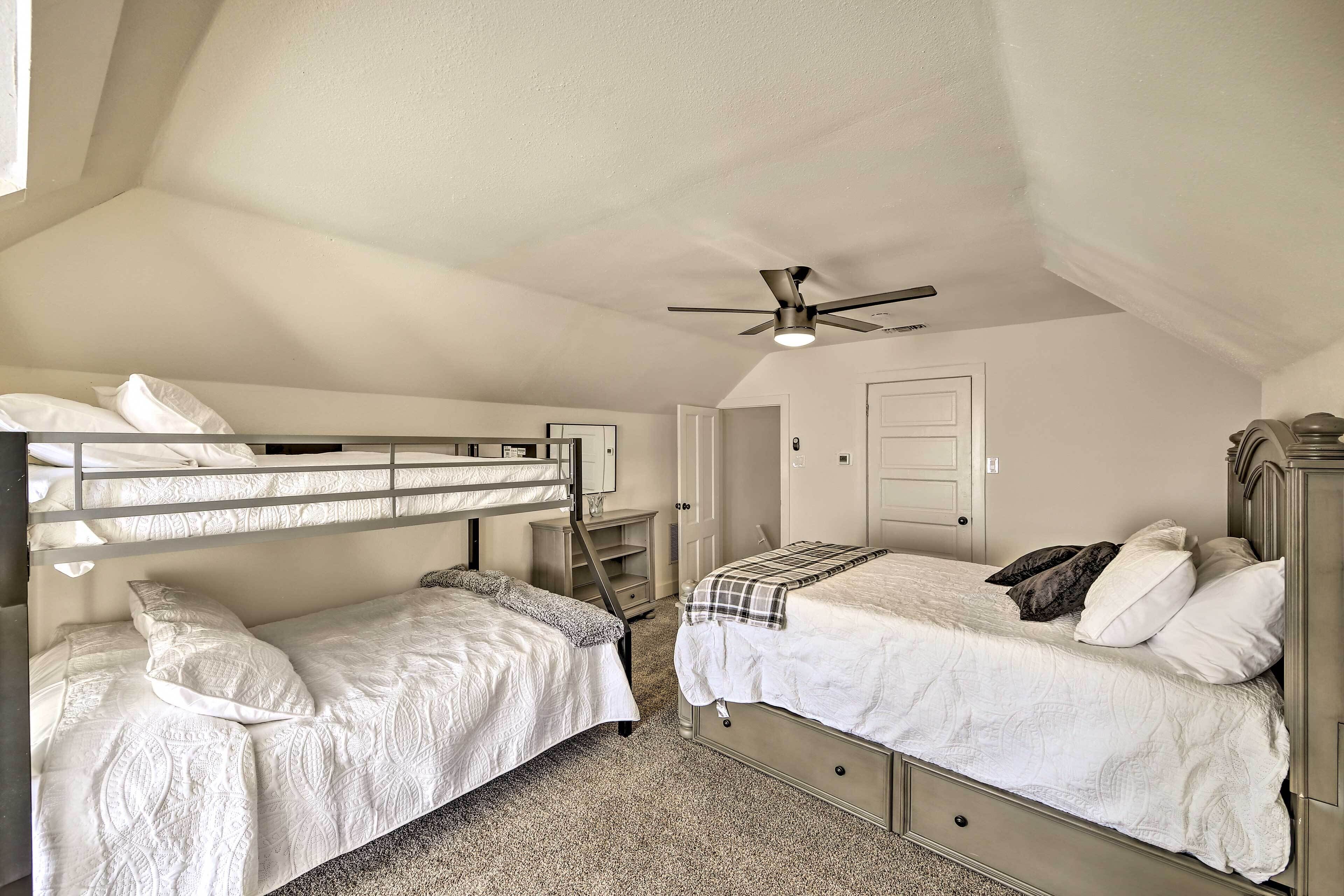 A bedroom with bunk beds, a ceiling fan, and a door.