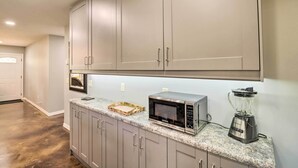 A kitchen with grey cabinets, a microwave, and a blender on the countertop. - Newly Built Cotter Home, Great Fishing Nearby (Cotter)
