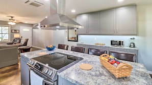 A modern kitchen with a central island, built-in microwave, and stainless steel appliances. - Newly Built Cotter Home, Great Fishing Nearby (Cotter)