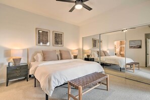 A bedroom with a bed, bedside tables, a bench, a ceiling fan, and a large mirror. - Pool Access at Pet-friendly Scottsdale Condo! (Scottsdale)