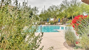 A swimming pool surrounded by greenery and outdoor seating. - Pool Access at Pet-friendly Scottsdale Condo! (Scottsdale)