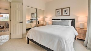 A bedroom with a large bed, bedside lamps, a mirror, and framed pictures on the wall. - Pool Access at Pet-friendly Scottsdale Condo! (Scottsdale)