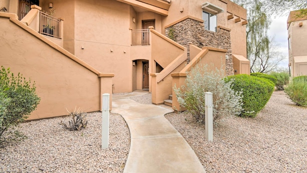 A building with a stucco exterior, a concrete pathway, and a stone accent wall. - Pool Access at Pet-friendly Scottsdale Condo! (Scottsdale)