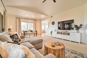 A modern living room with a sofa set, a wooden coffee table, and a TV on a white cabinet. - Pool Access at Pet-friendly Scottsdale Condo! (Scottsdale)
