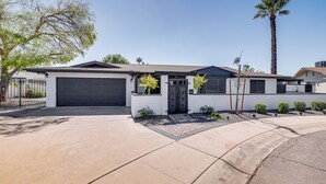 A modern two-story house with a garage, a driveway, and a palm tree. - Private Pool & Grill: Scottsdale Getaway! (Scottsdale)