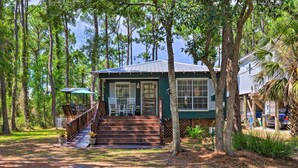 A two-story house with a porch, a covered deck, and a staircase leading to the entrance. - Charming Dauphin Island Home ~ 1 Mi to Beach! (Dauphin Island)